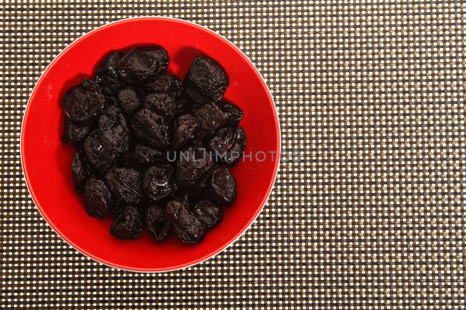 A pile of prunes on a bowl.