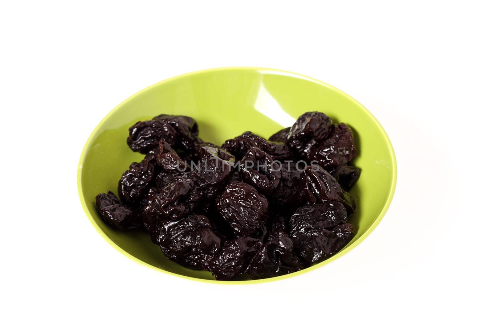 A pile of prunes on a bowl, isolated.