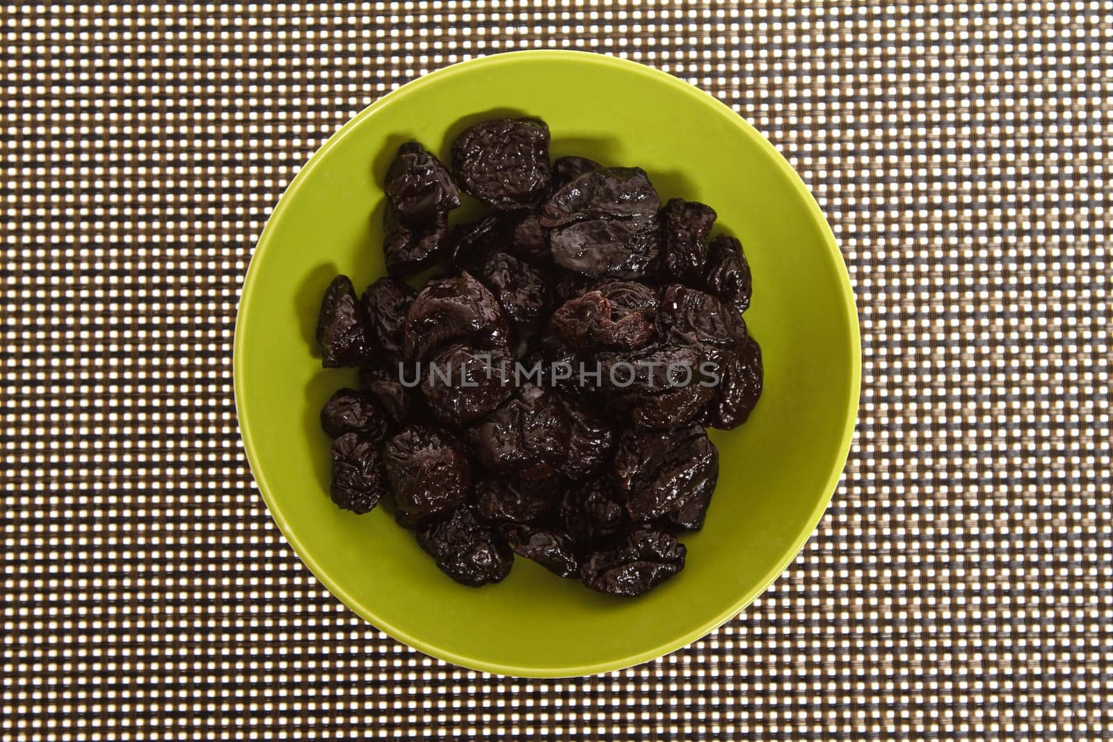 A pile of prunes on a bowl.