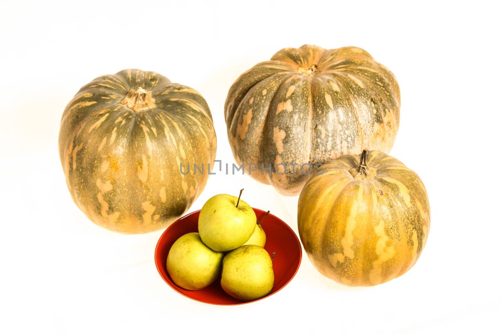 Pumpkins and green apples on a white background, isolated.