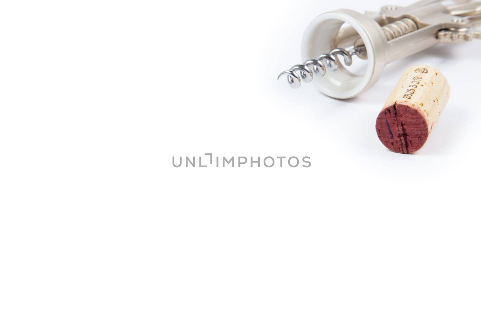 Wine cork and corkscrew on white background