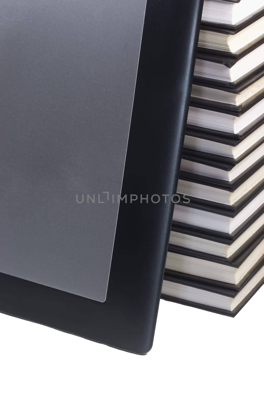 Tablet leaning on books. White background.
