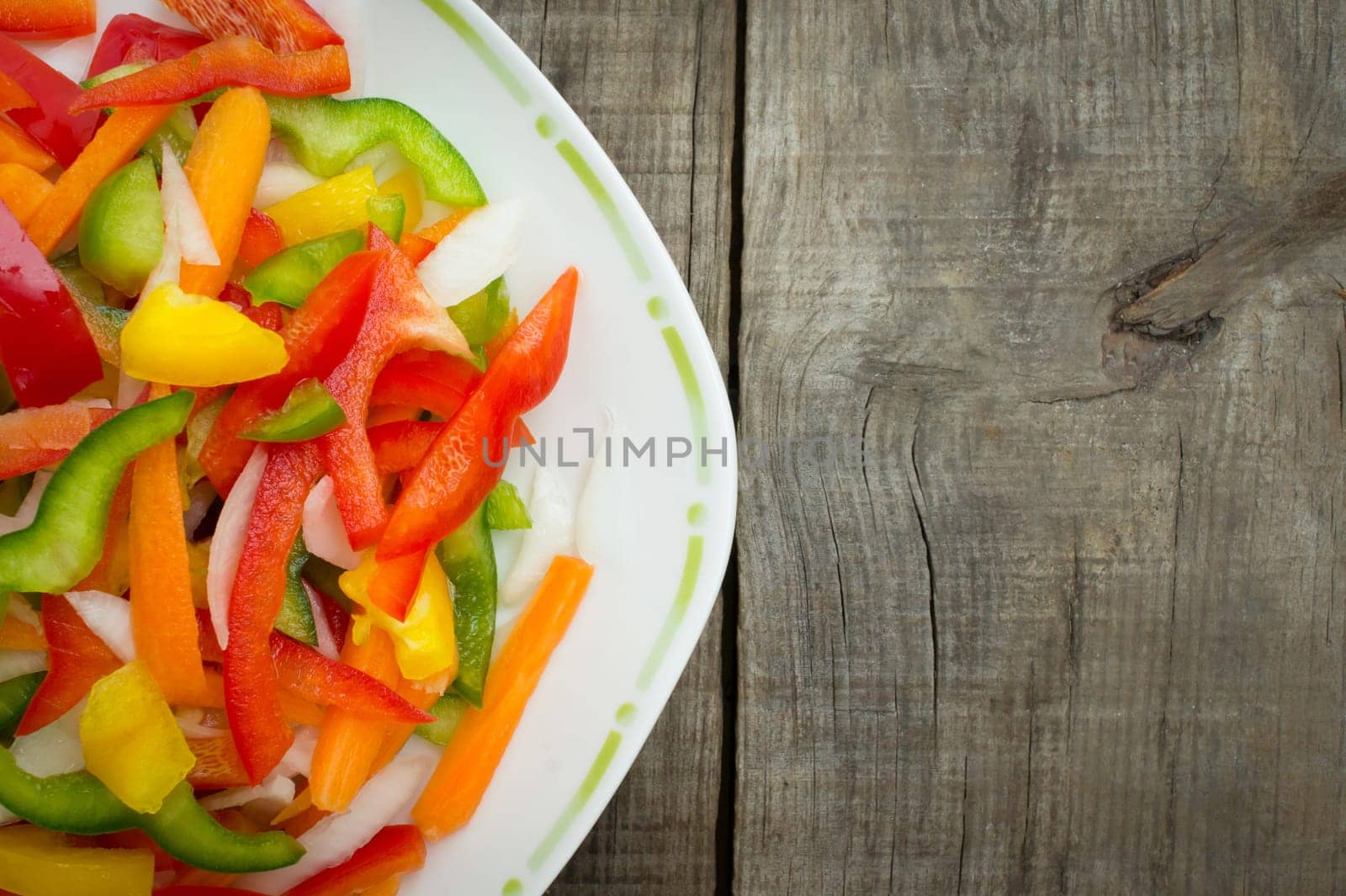A plate of vegetable slices on wood background
