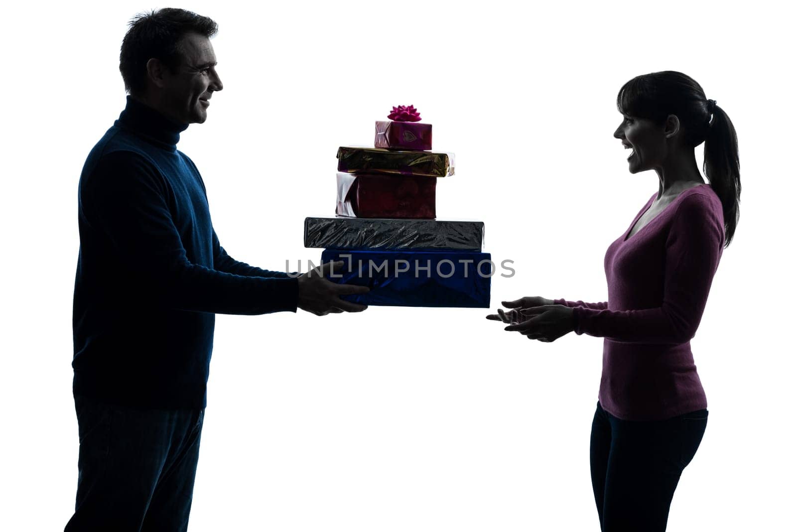 one caucasian couple woman man offering christmas  gifts in silhouette studio isolated on white background