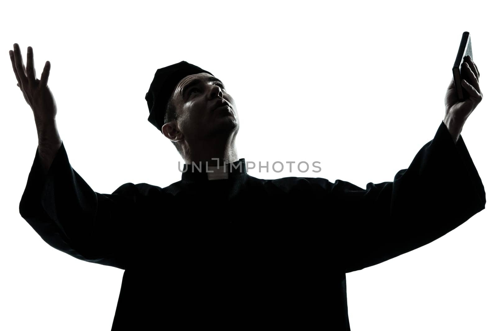 one caucasian man priest praying silhouette in studio isolated on white background