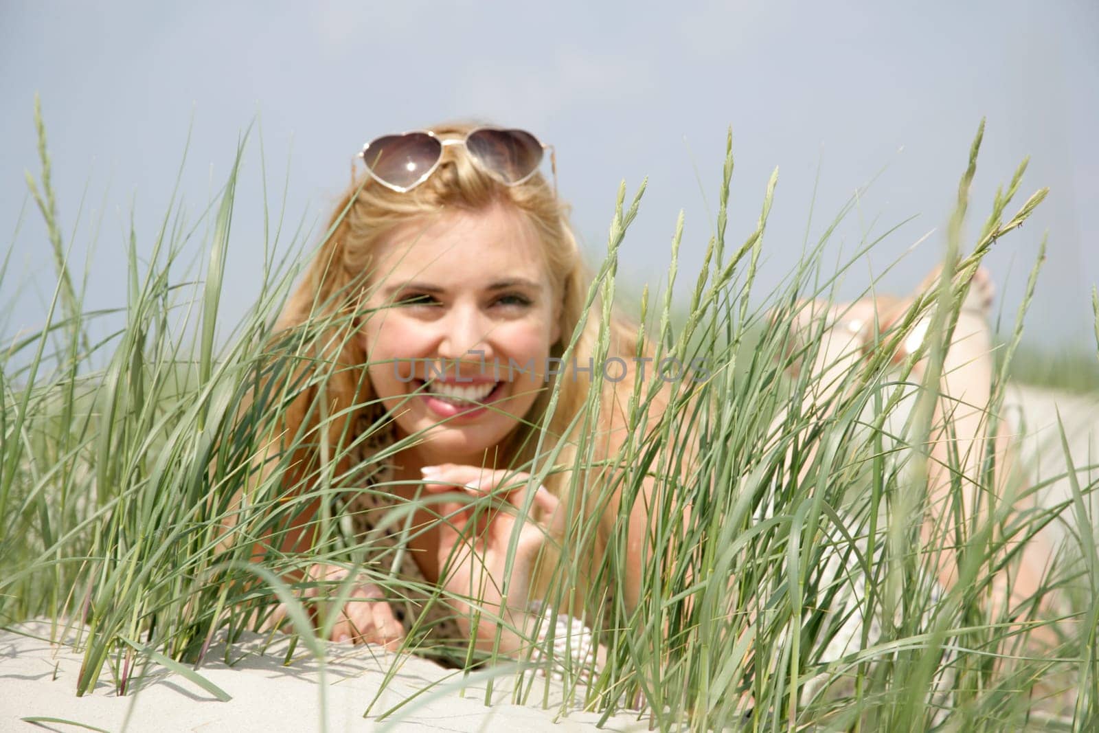 Young woman lies in the dunes