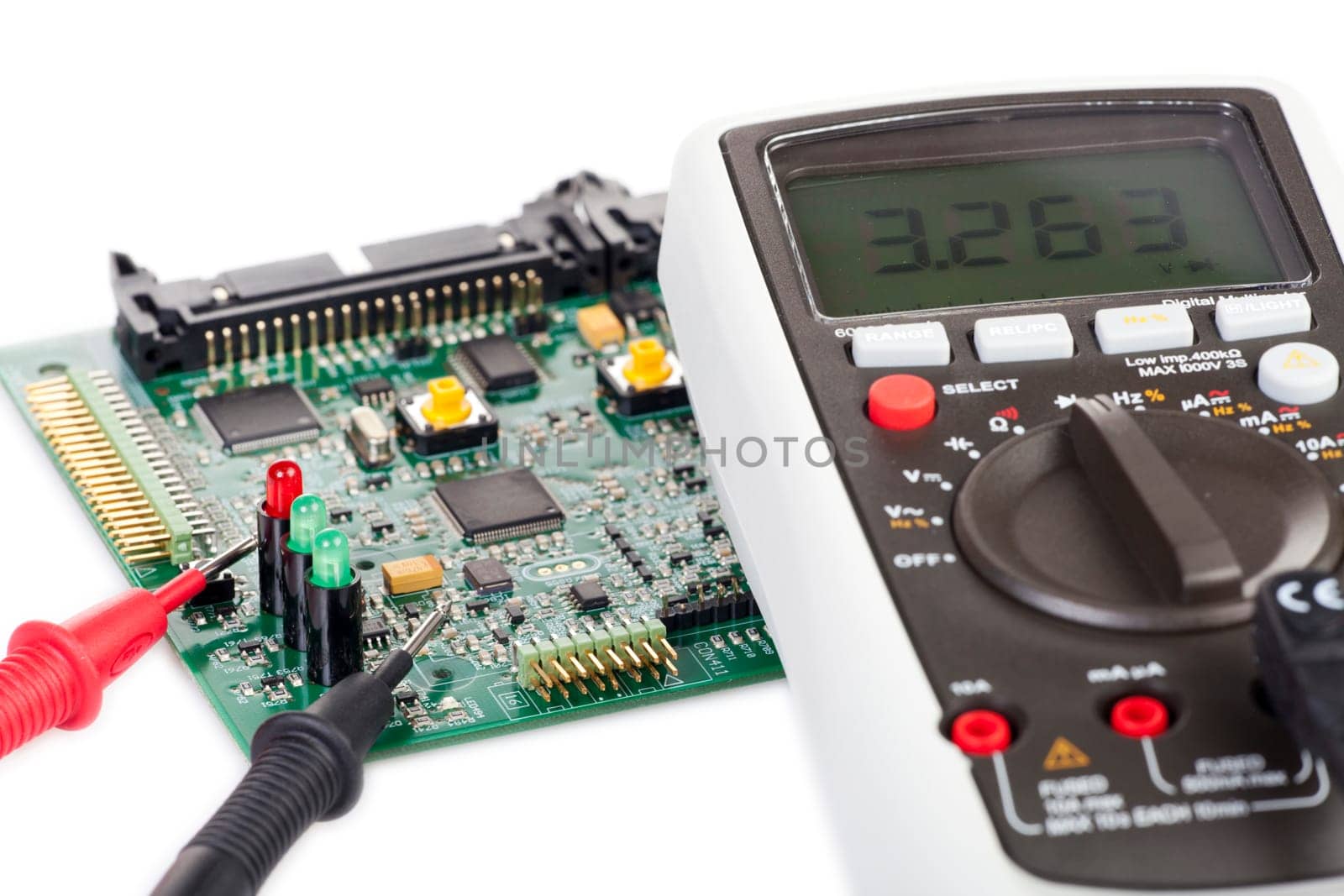 Digital multimeter and board on white background