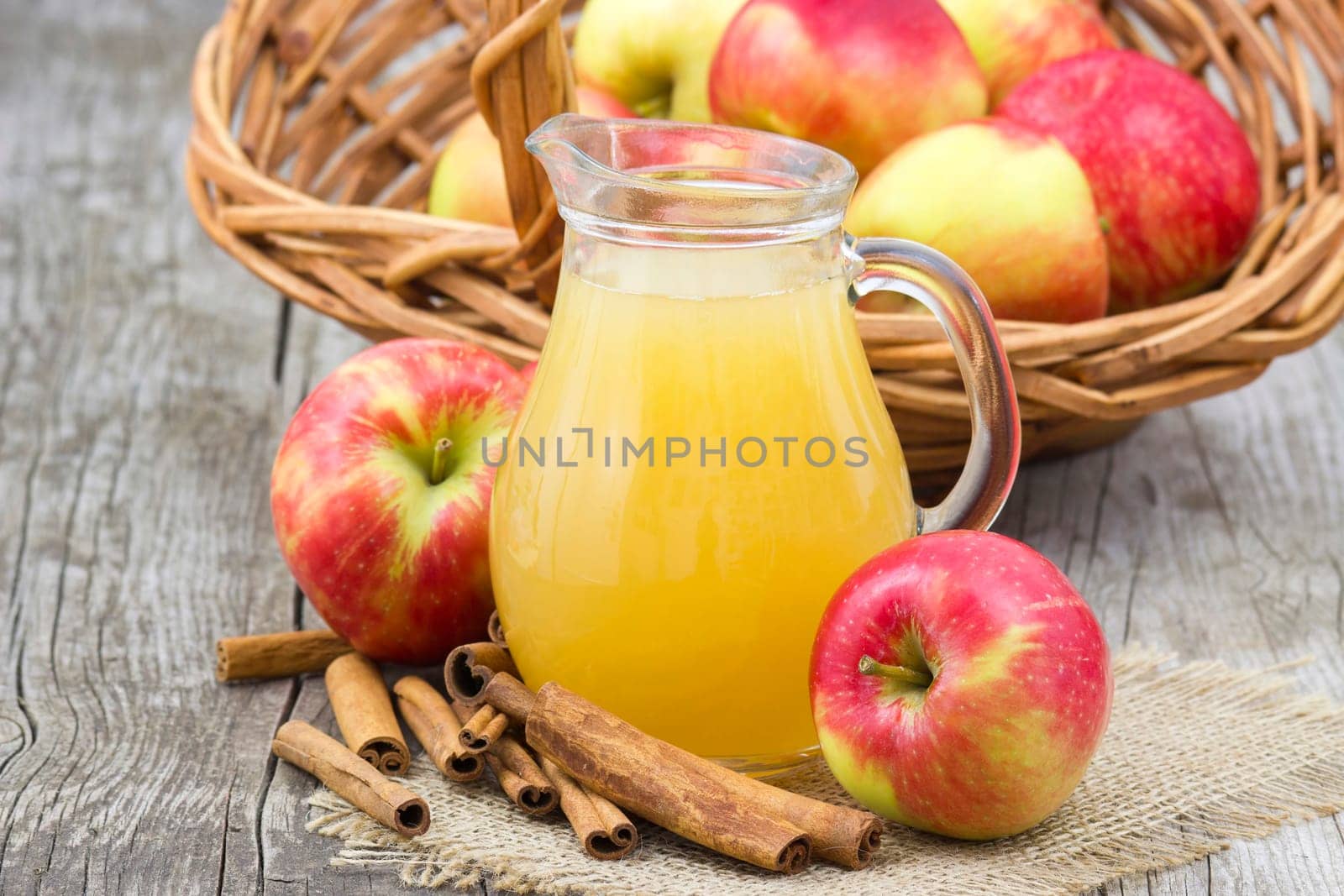 Apple juice and apples on wooden background
