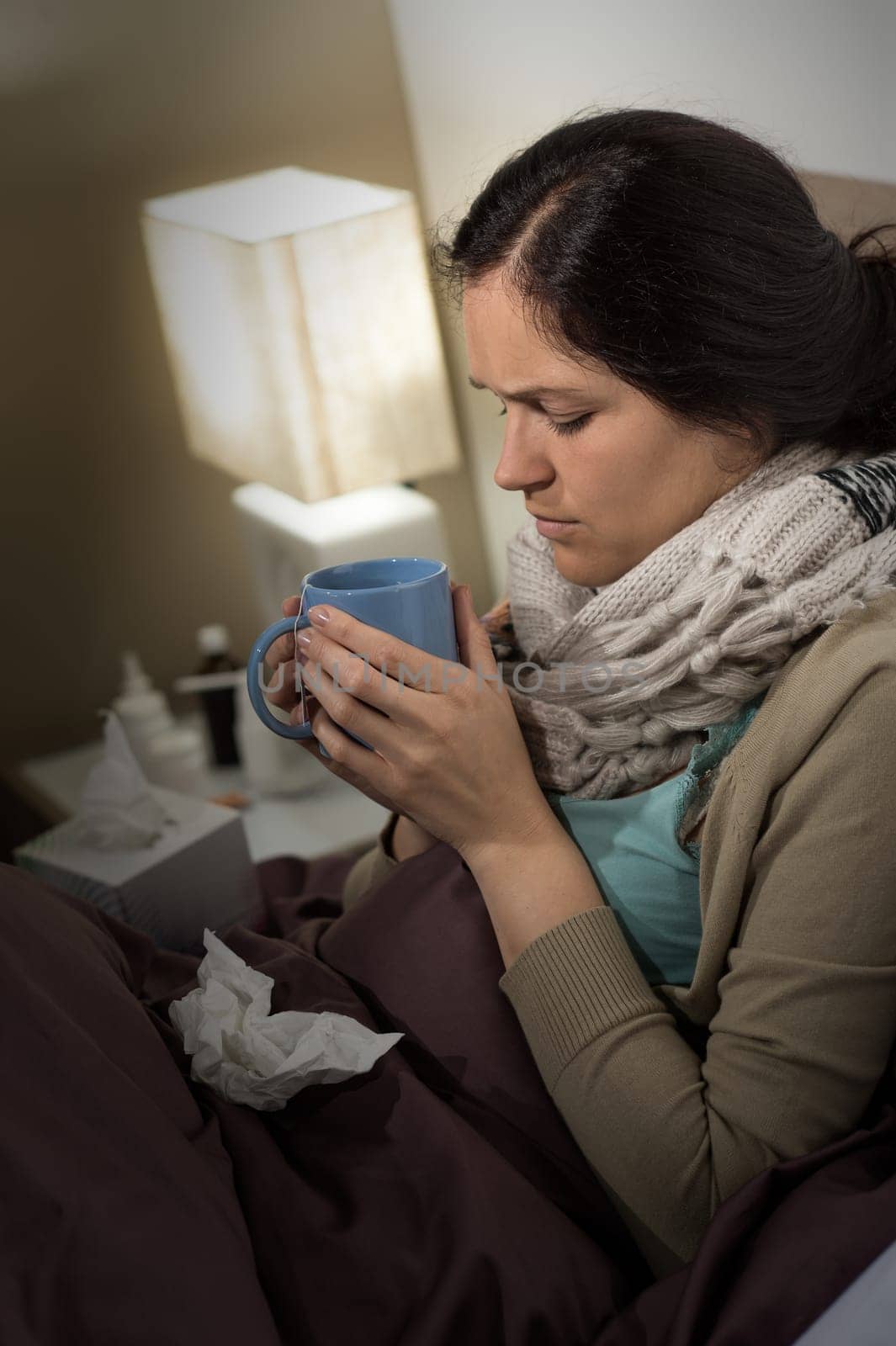 Portrait of young sick woman drinking tea suffering from cold