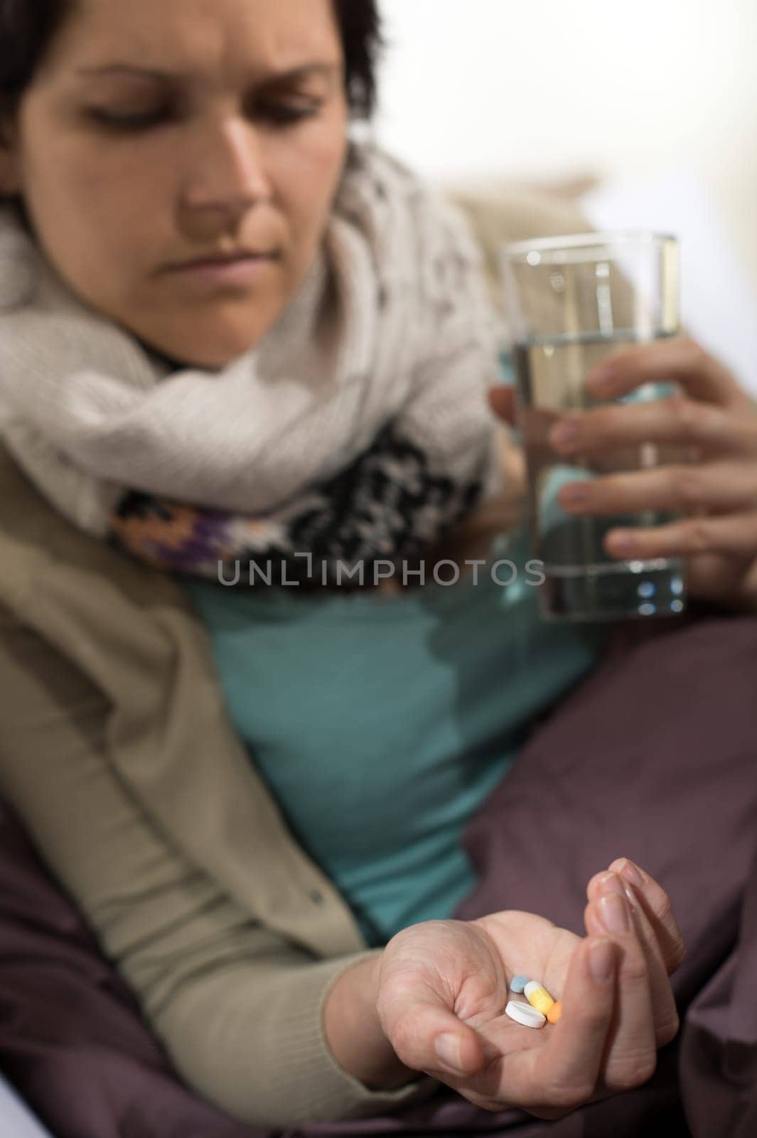 Sick woman taking pills for flu