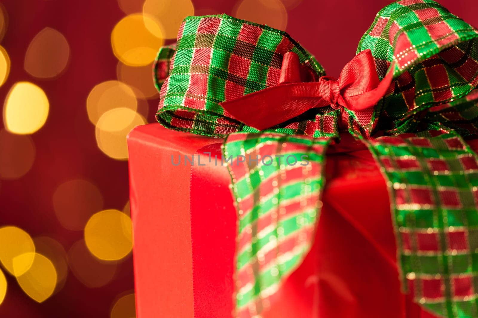 Christmas gift and sparkling defocused lights background red and green