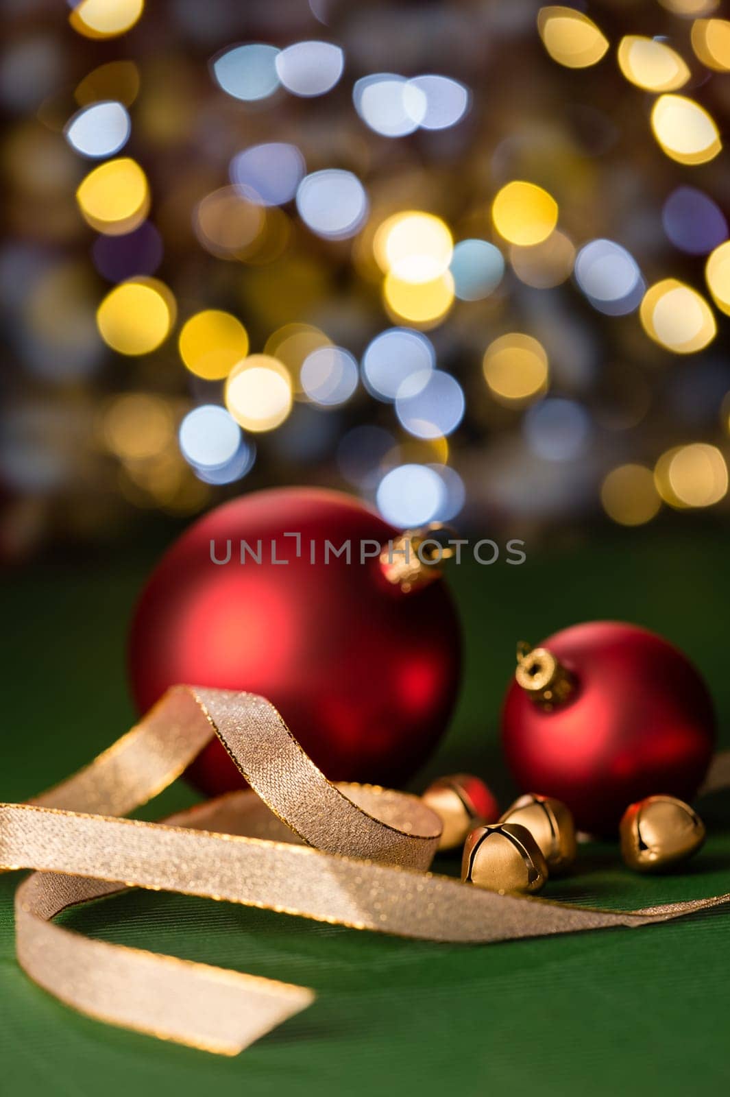 Red christmas baubles and gold jingle bells with sparkling lights