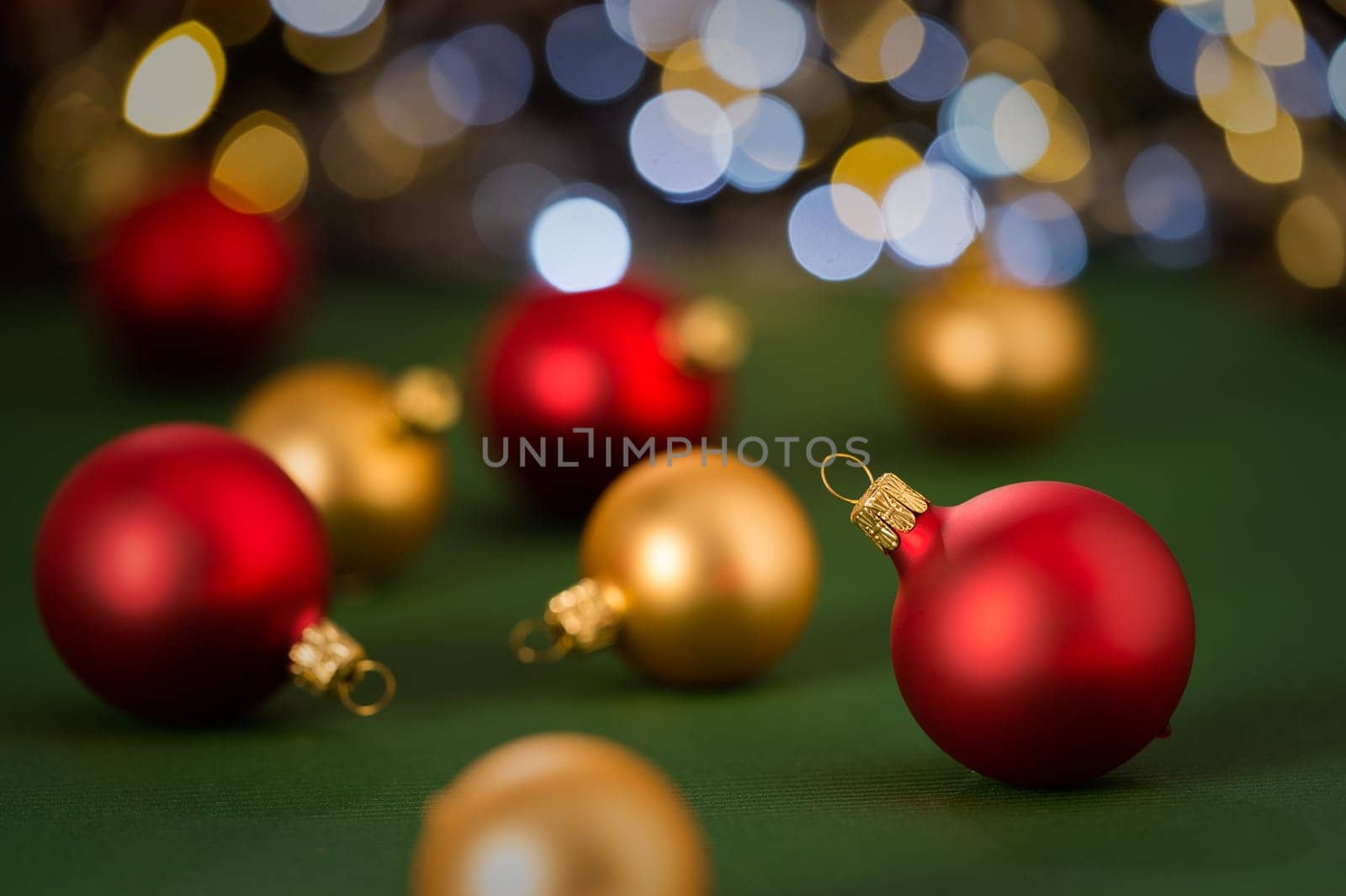 Christmas red and golden baubles on green color paper in the background