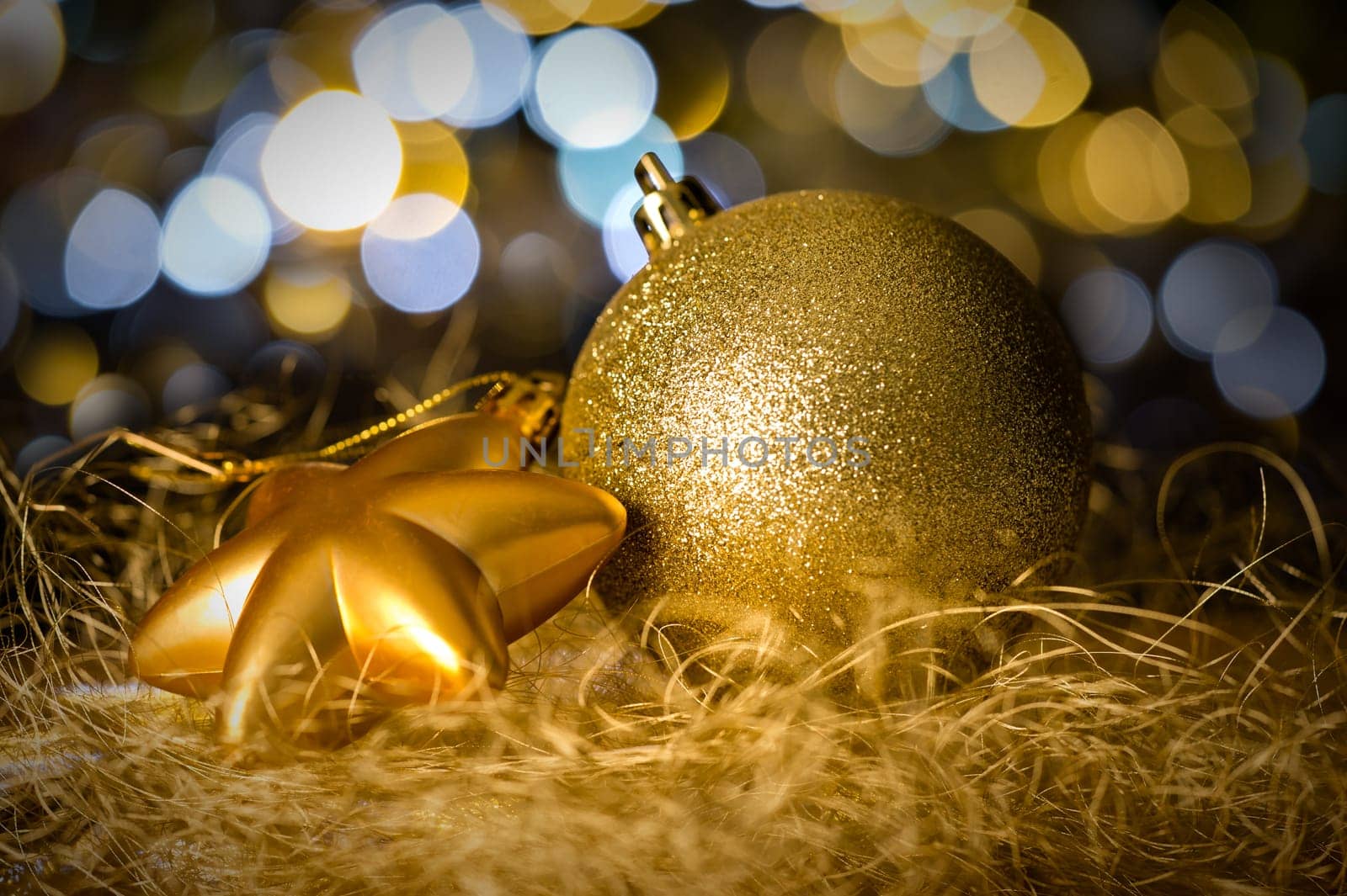 Gold christmas bauble and star decoration on dark lights background