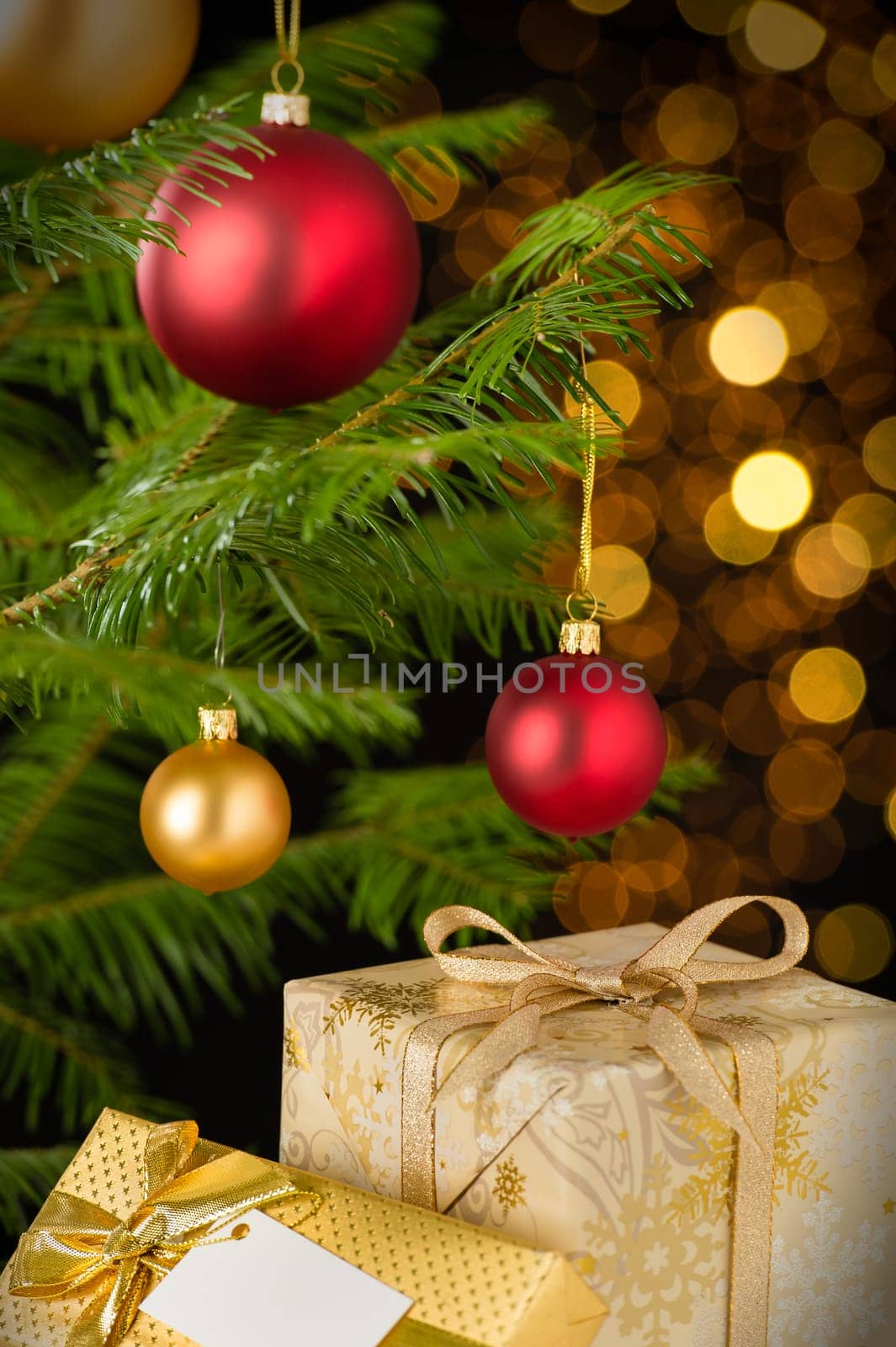 Christmas decoration tree, baubles and gifts on shining lights background
