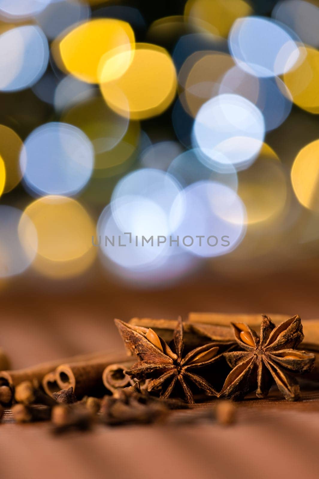 Christmas spices clove, star anise and cinnamon sparkling lights background