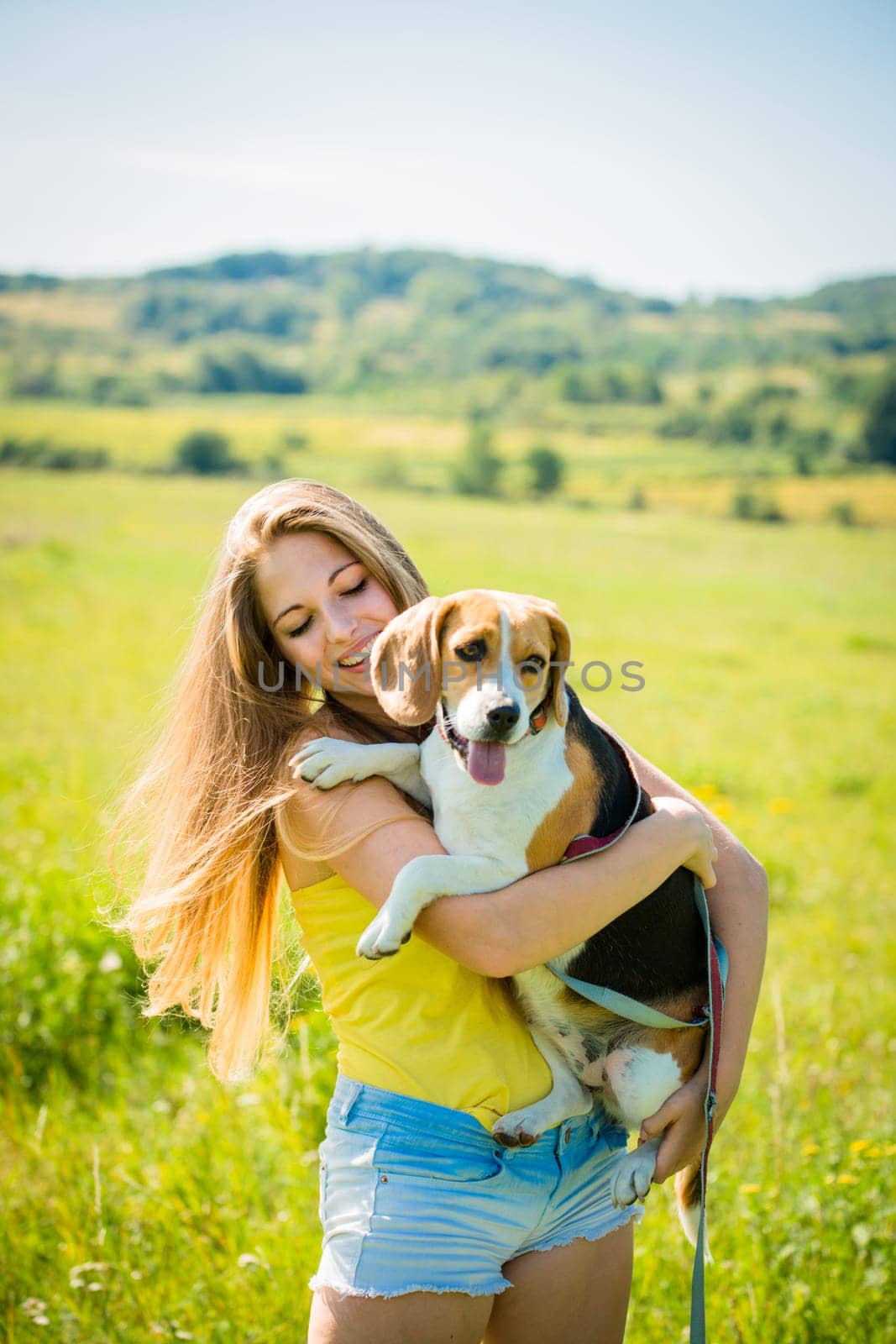 Teen girl holding her pet (beagle dog) - outdoor in nature