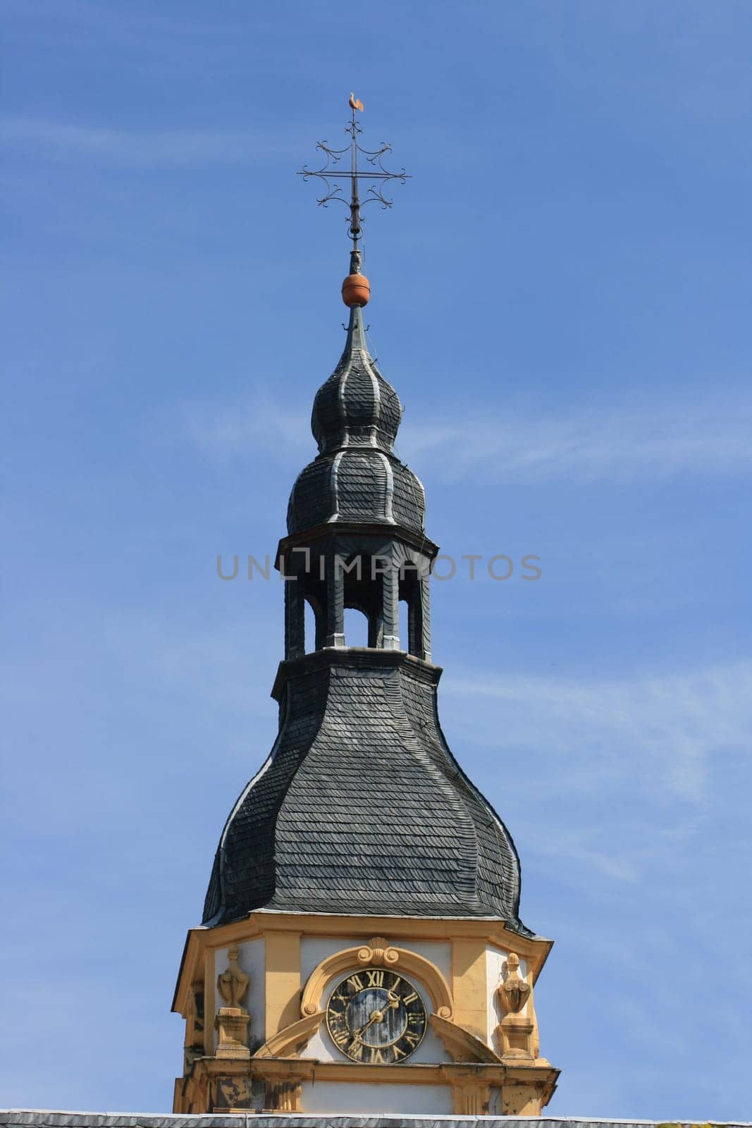 Church tower with a beautiful clock and blue sky in the background