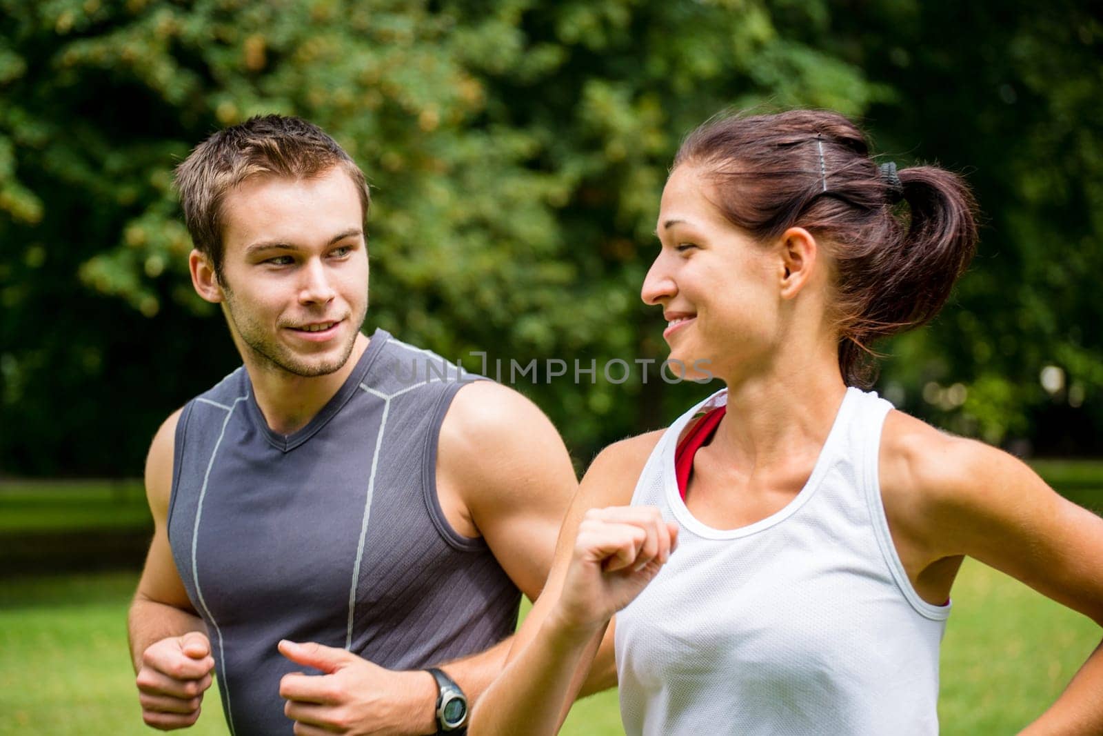 Young man and woman jogging outdoor and looking on each other