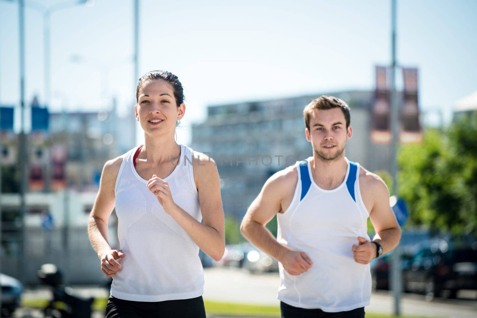 Young sport couple jogging together in city environment