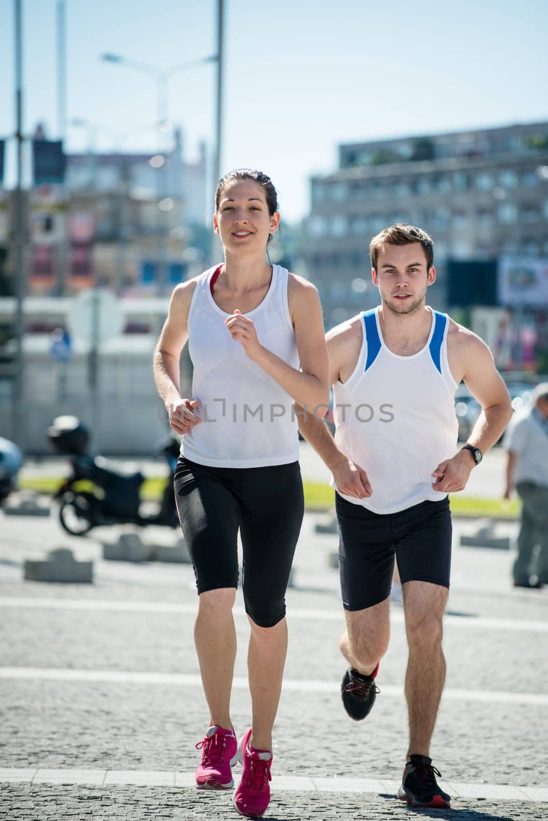 Young sport couple jogging together in city environment