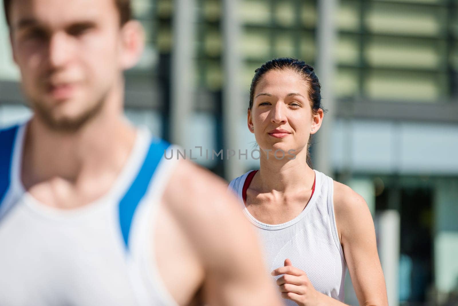 Young sport couple jogging in city environment - man cropped