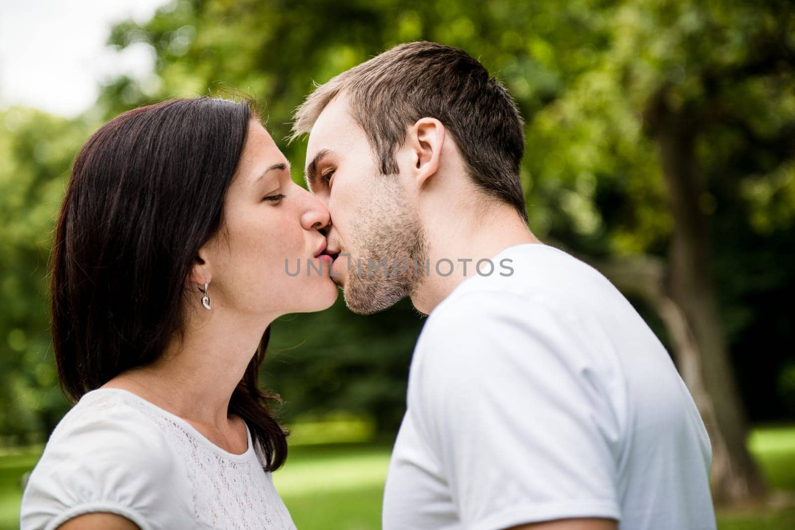 Young happy couple kissing - outdoor lifestyle portrait