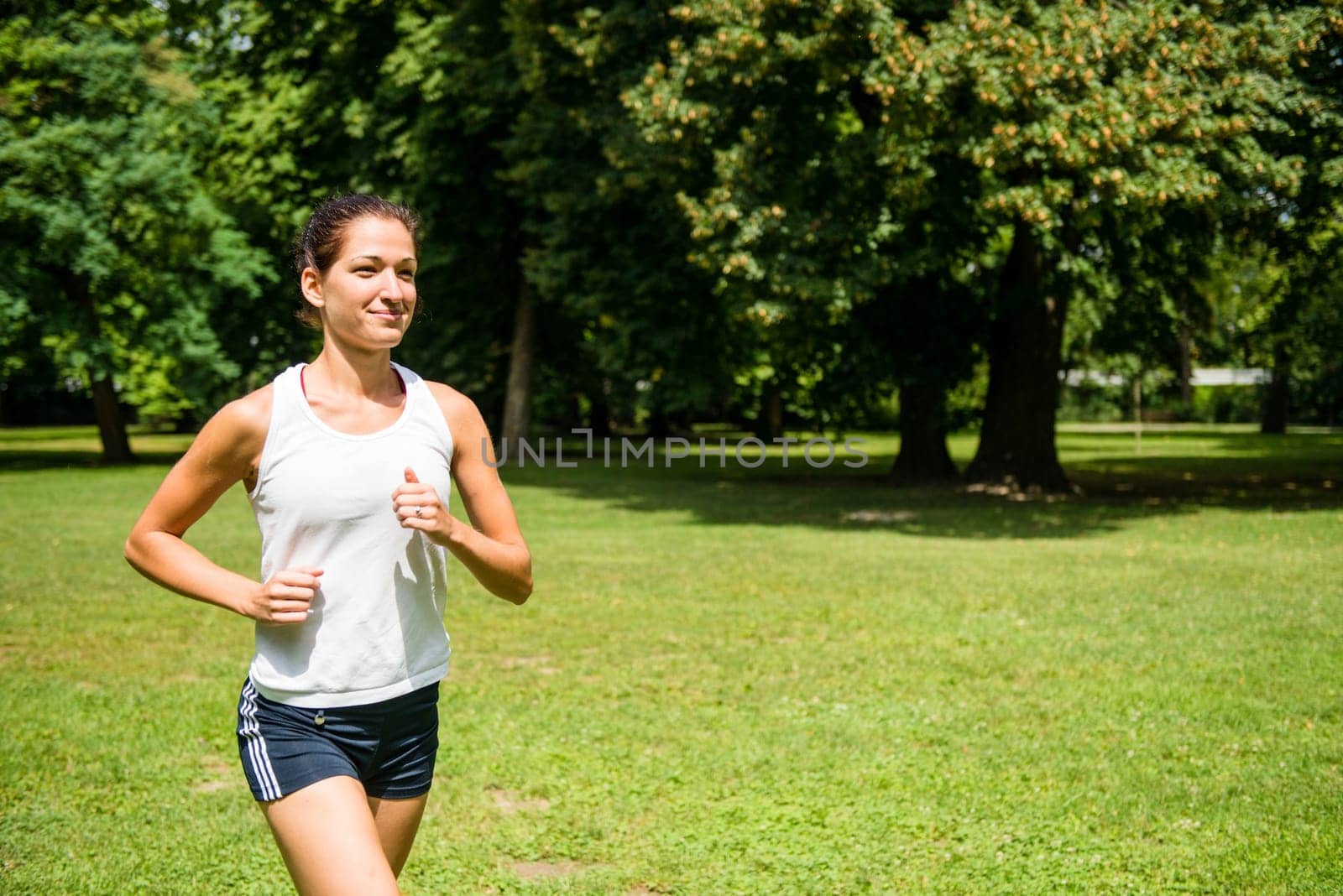 Jogging lifestyle - young beautiful woman running in park