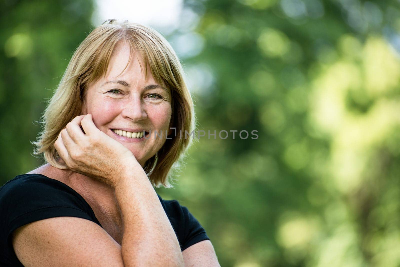 Portrait of happy smiling senior woman - outside on sunny day
