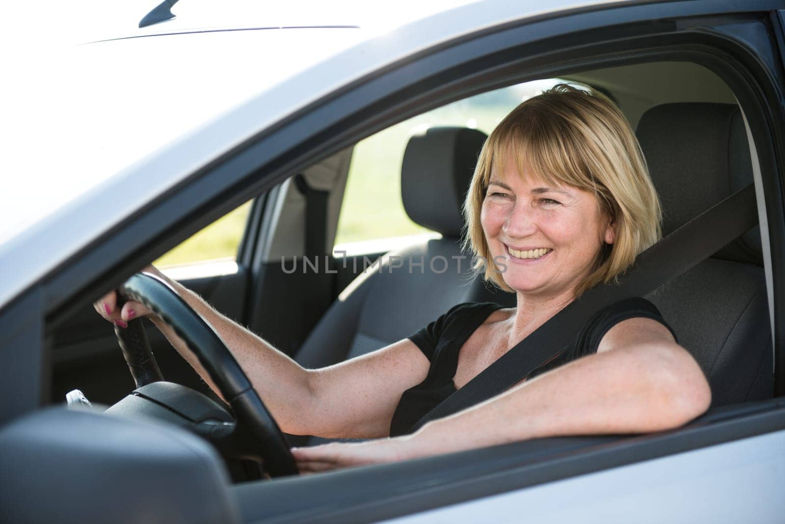 Lifestyle photo of attractive senior woman driving car