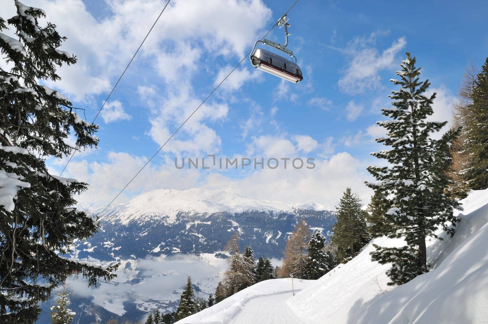Empty ski lift in beautiful winter snowy mountain landscape (resort in Alps)