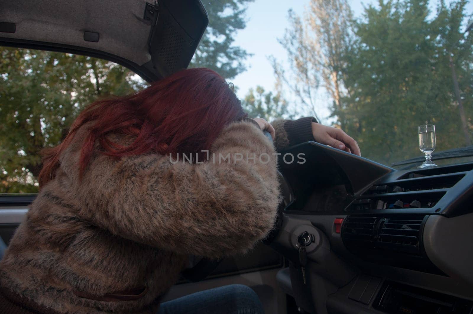 drunk woman driving car with vodka in hand