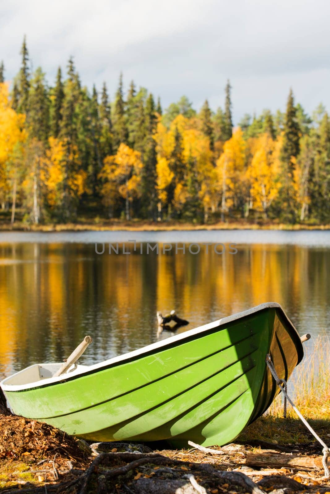 Boat bound by rope at rough lake shore