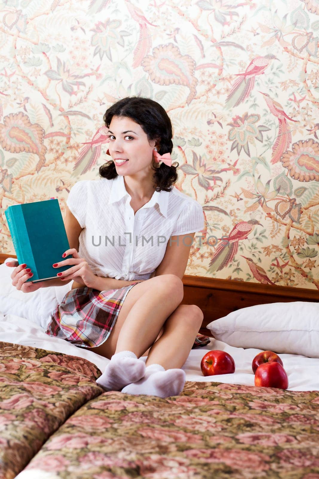 Happy woman in schoolgirl dress with mysterious book