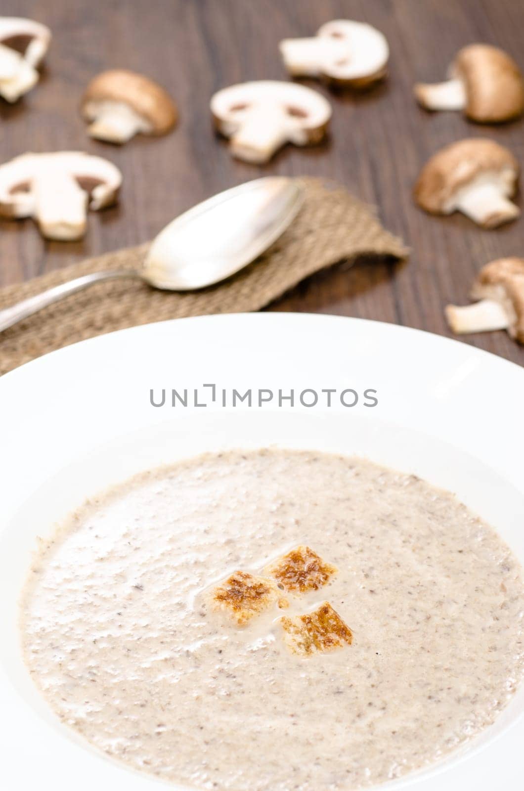 Mushroom soup with mushrooms and croutons in portrait format