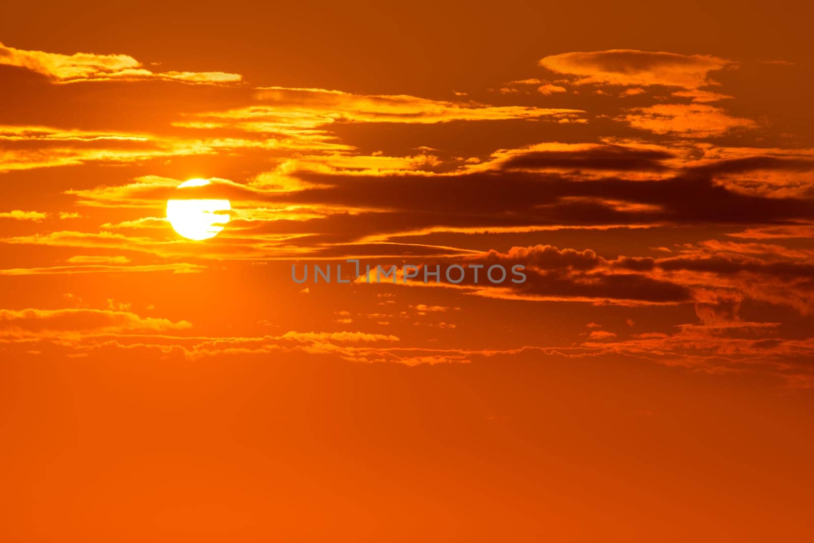 Sunset orange sky background at evening with clouds