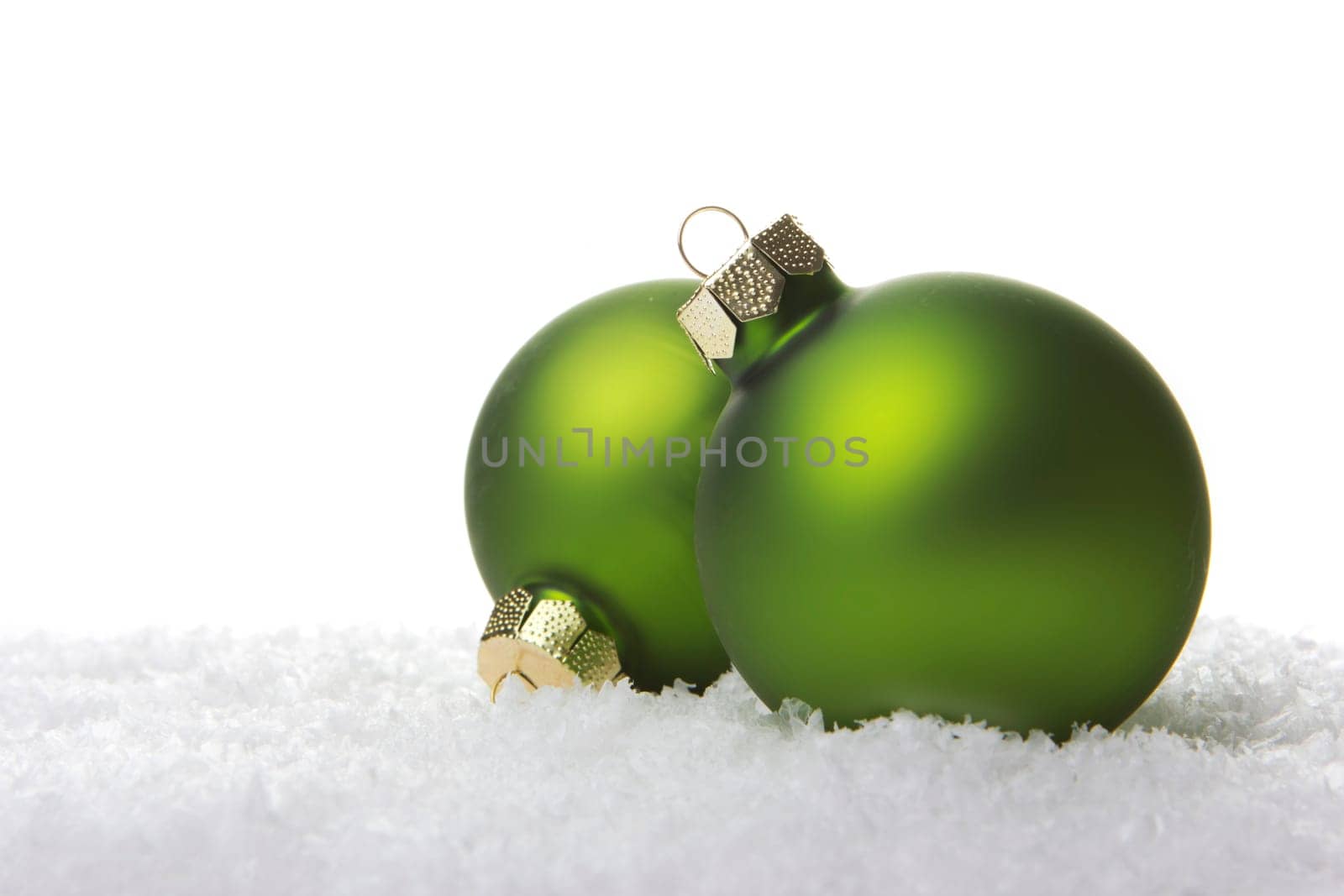 Christmas baubles green on artificial snow with white background