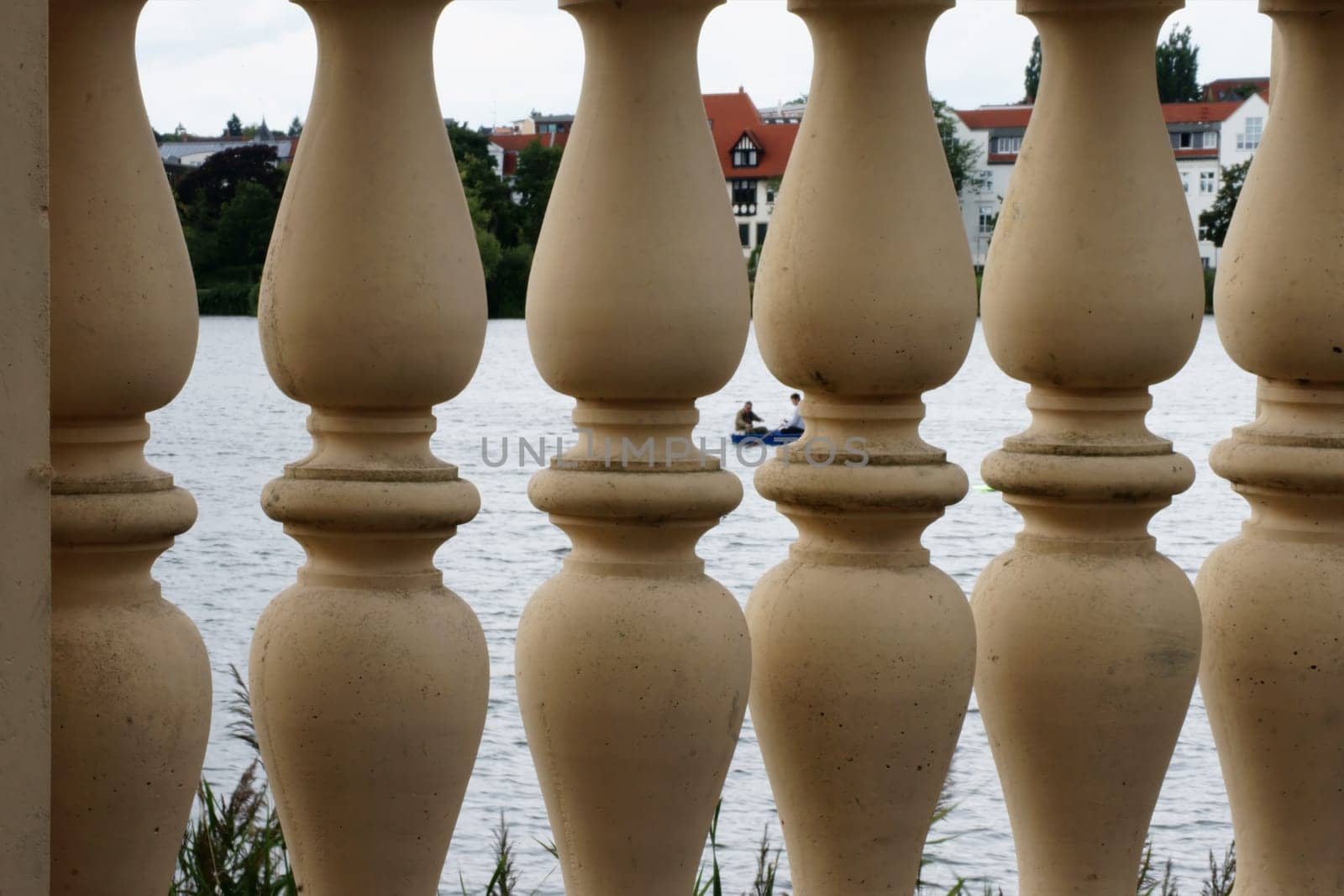 The photograph of pillars of a wall on a lake