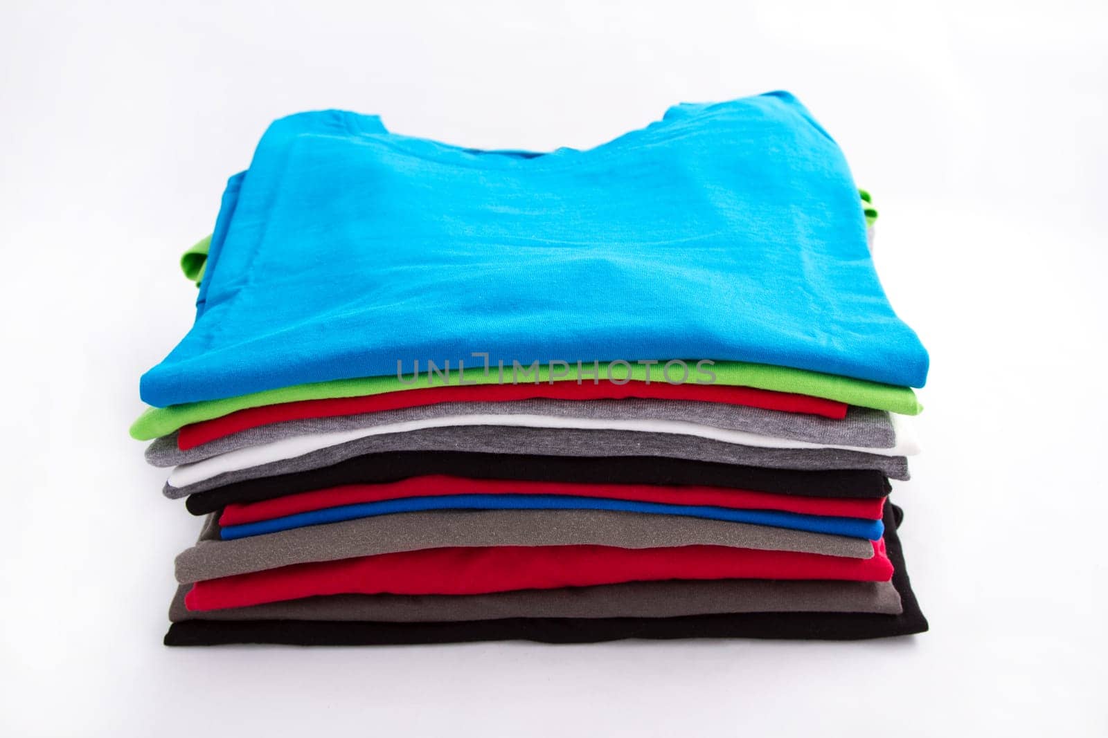 A pile of folded T shirts .
