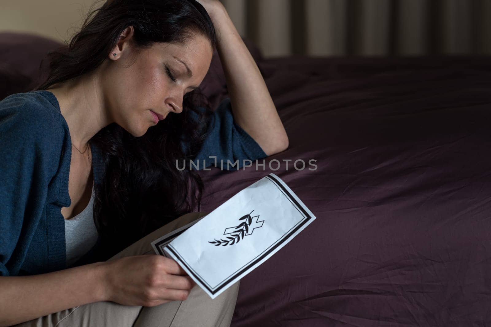 Sad Caucasian woman with death notice in hand