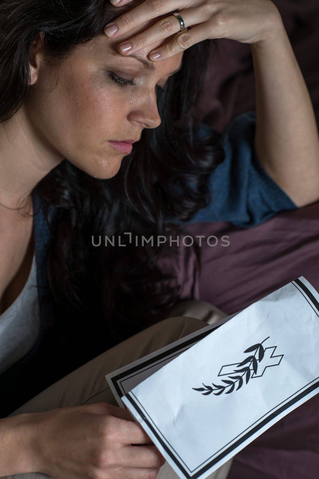 Close up portrait of mourning woman holding obituary