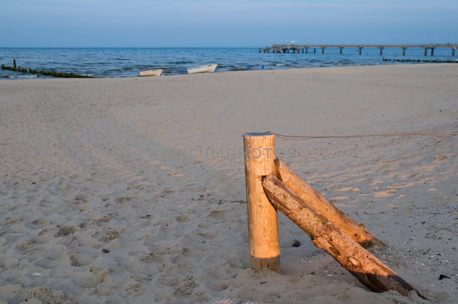 flat fence post with tensioned wire on the sandy beach near the city of Bansin / Usedom / Germany in summer