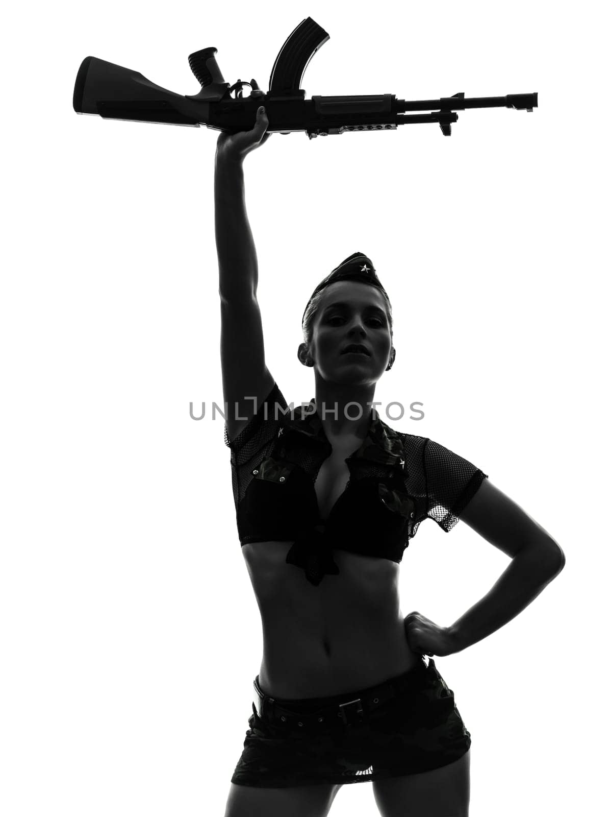 one caucasian sexy woman in army uniform saluting with kalachnikov in silhouette studio isolated on white background