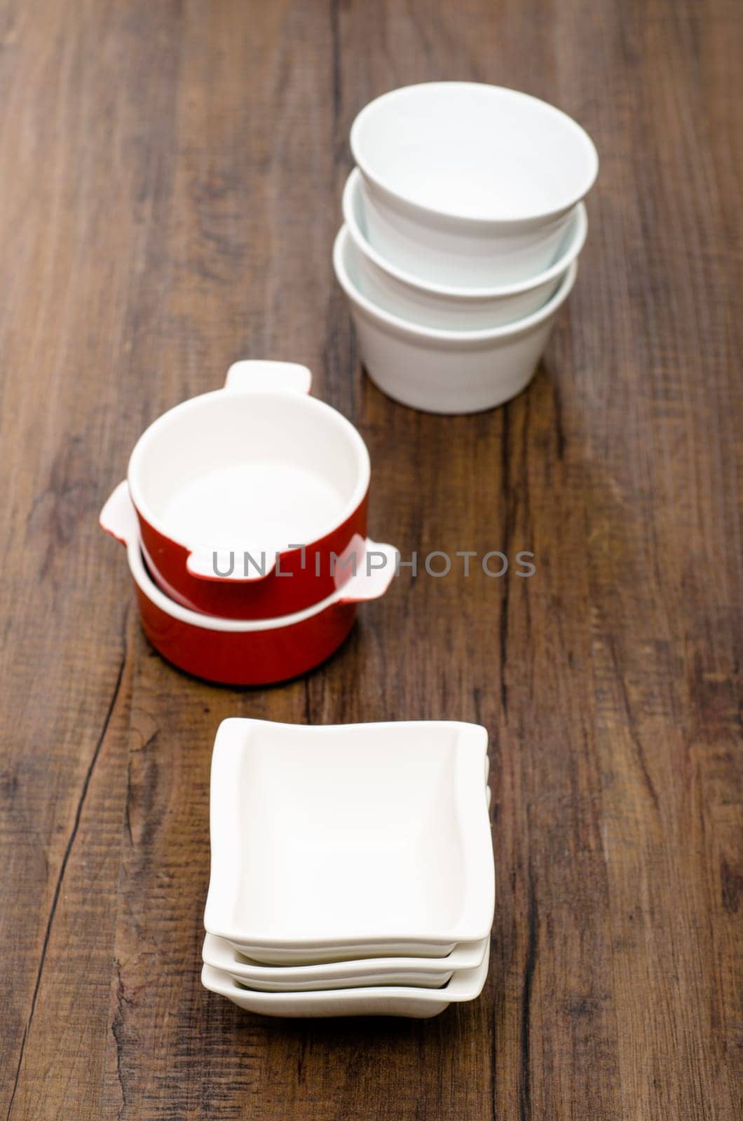 Various porcelain bowls in portrait format on brown wood