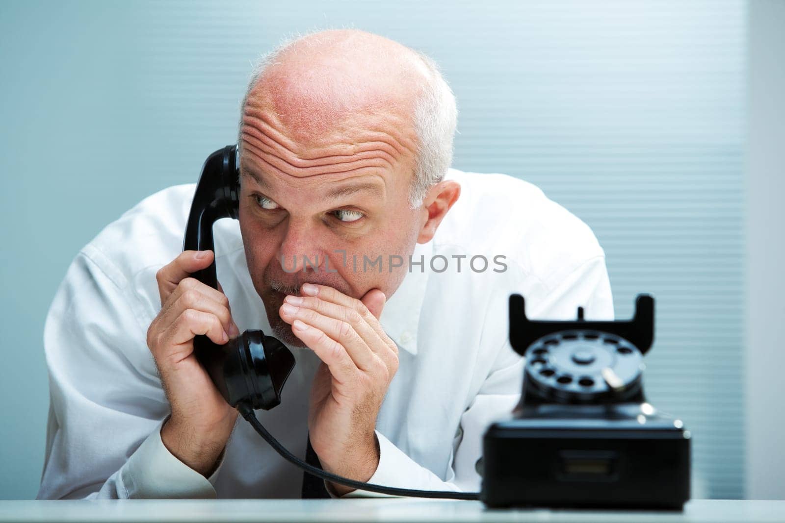 Businessman blurting by phone (focus on the man)