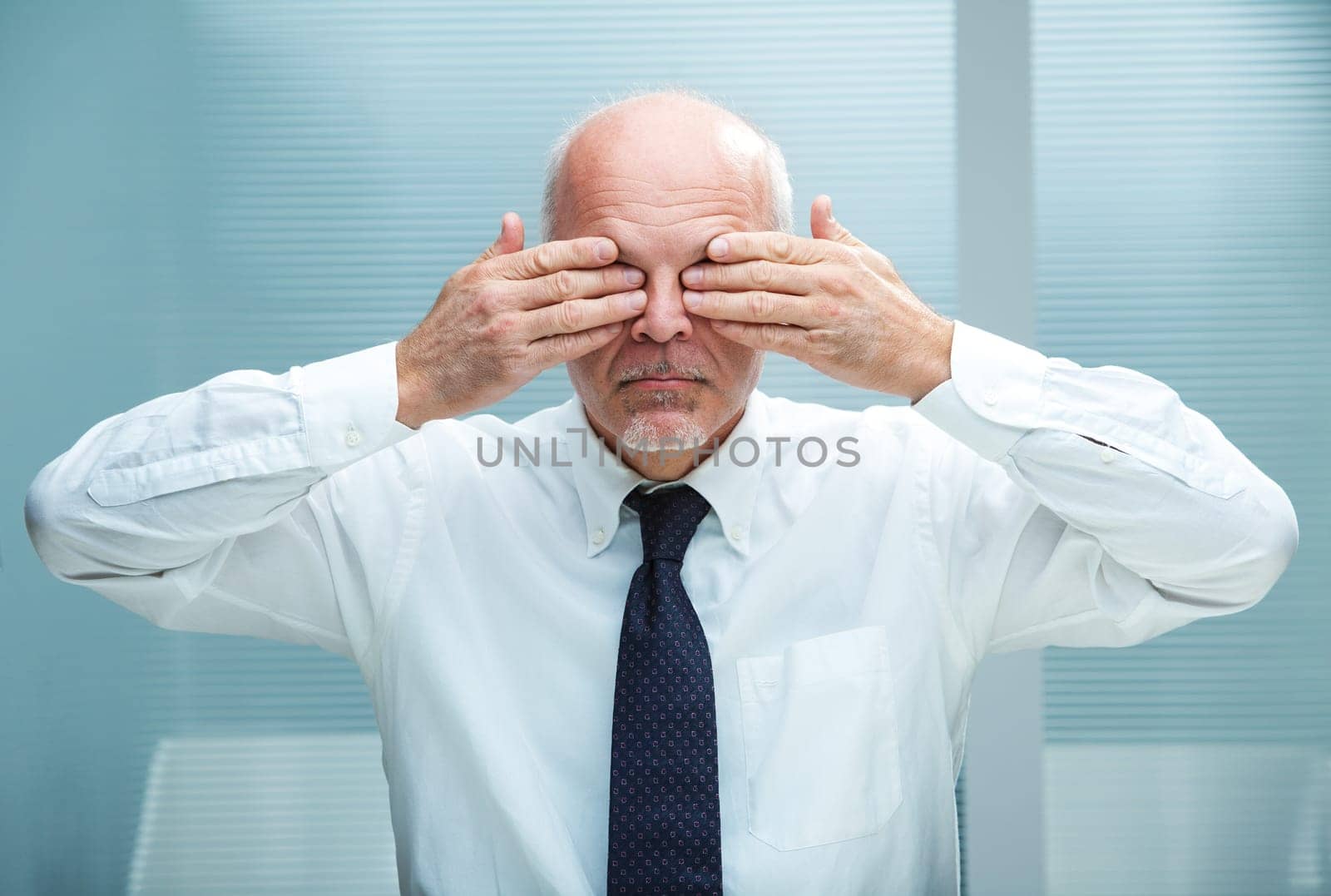 businessman covering his eyes with his hands