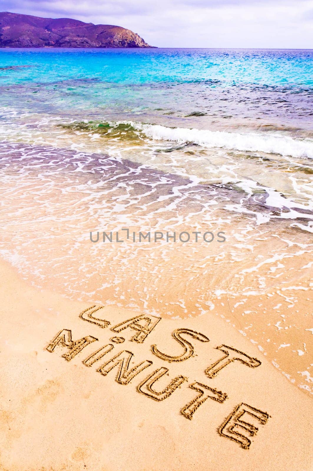 Last Minute written on sand, being washed away by waves, vacation concept