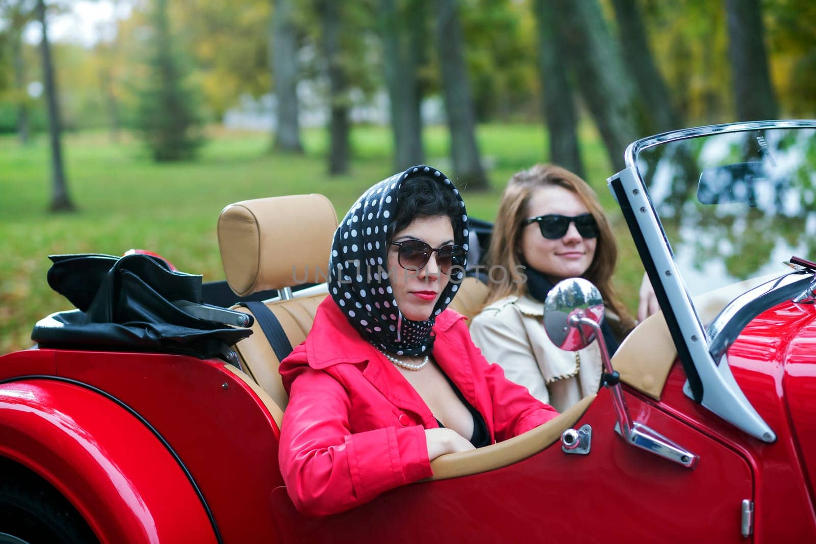 women in black on red car on vacation