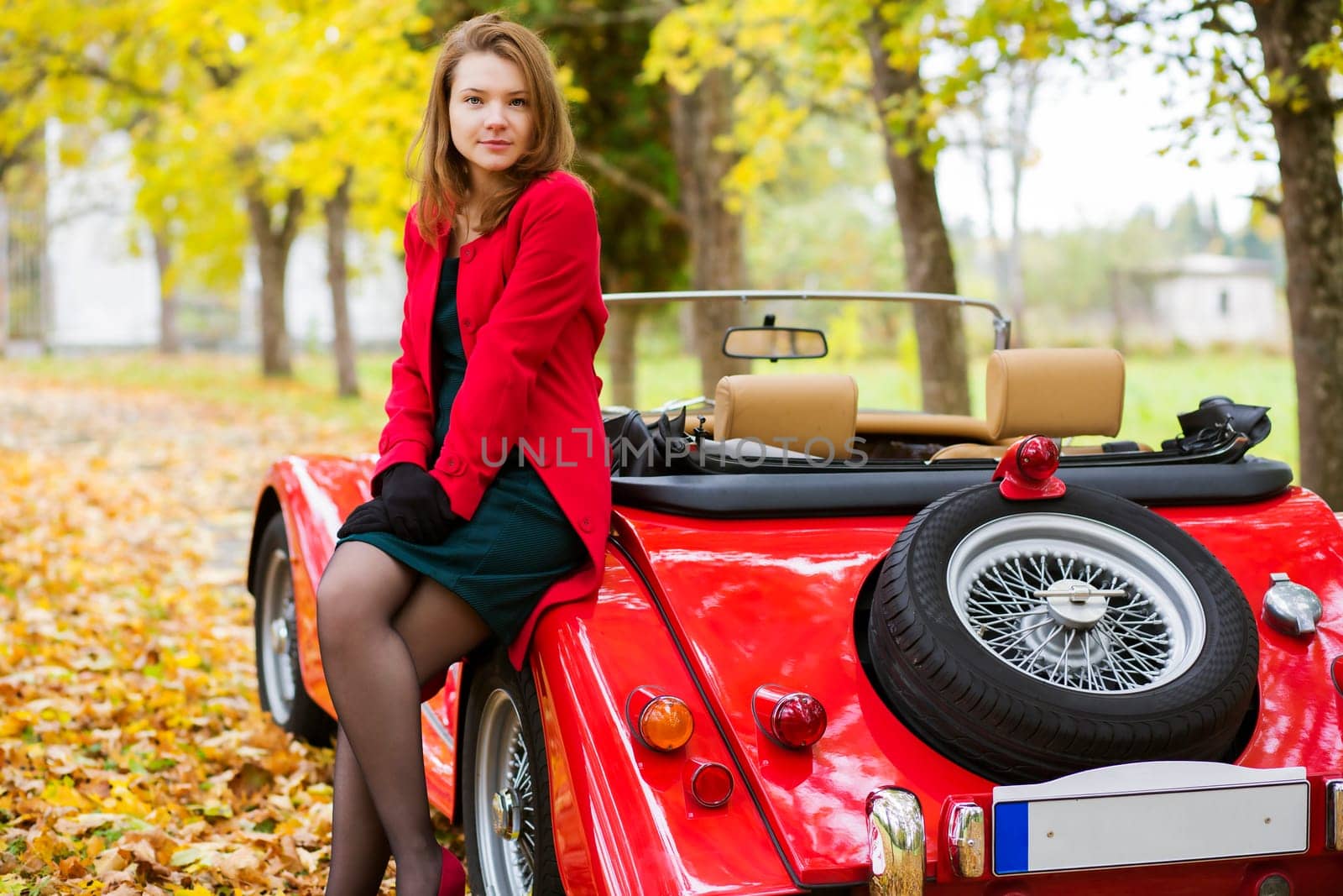 Woman in red and car at autumn park