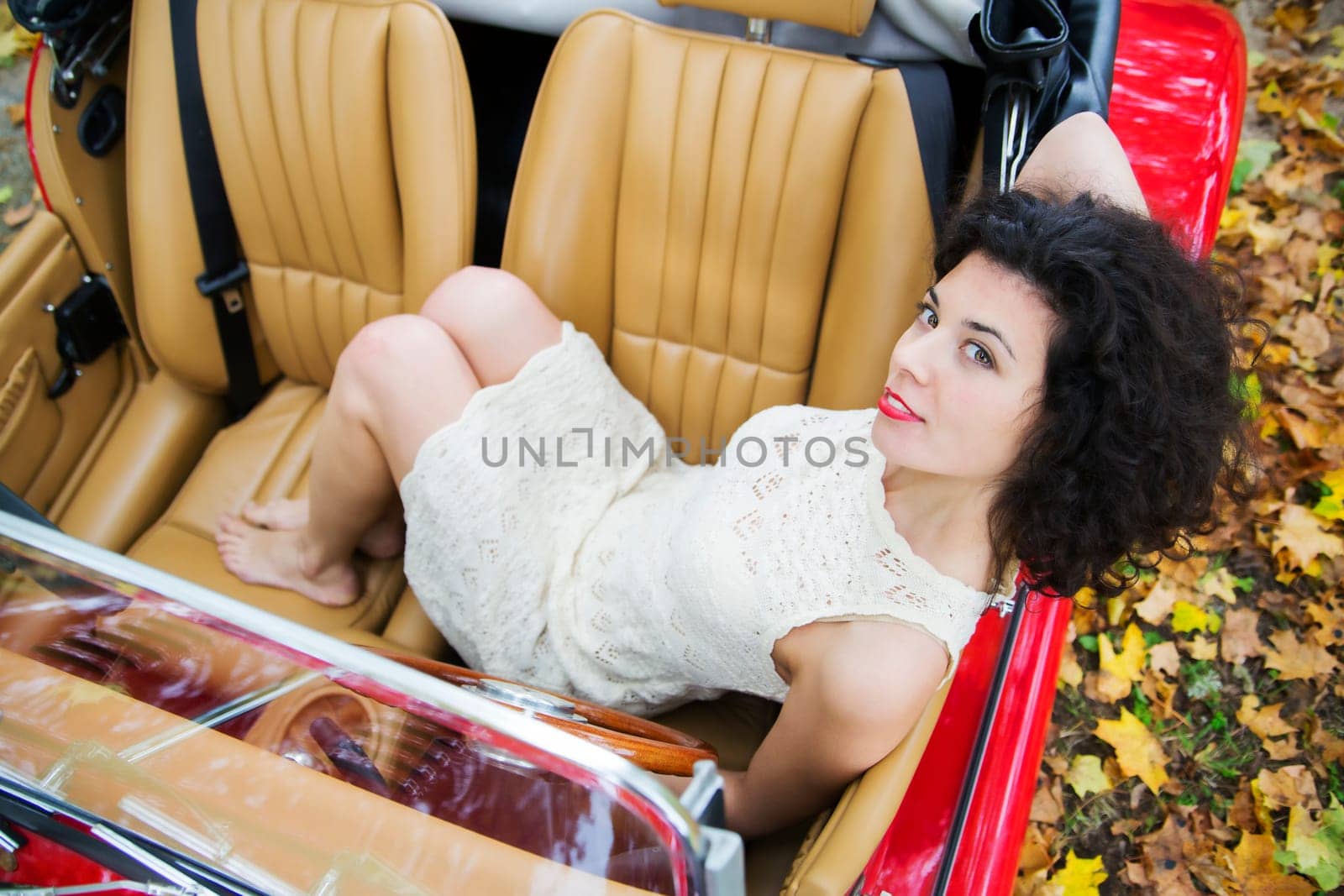Woman in white dress in two seat car